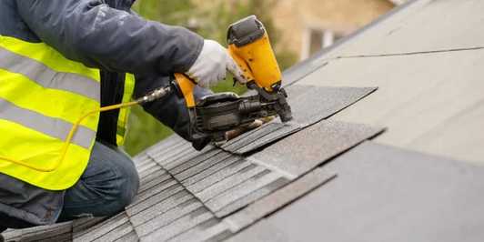 Photo of a roofering working dilligently to roof a house in a professional manner