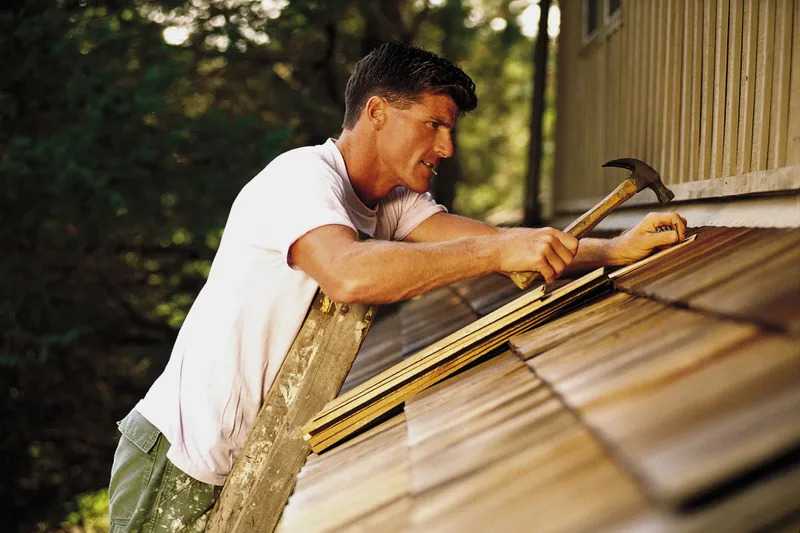 Roofer installing shingles